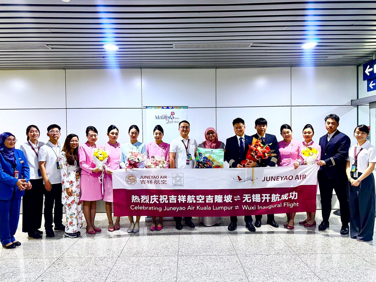 A commemorative photo session with representatives from Tourism Malaysia alongside Juneyao Airlines cabin crew and Post Aviation representatives.