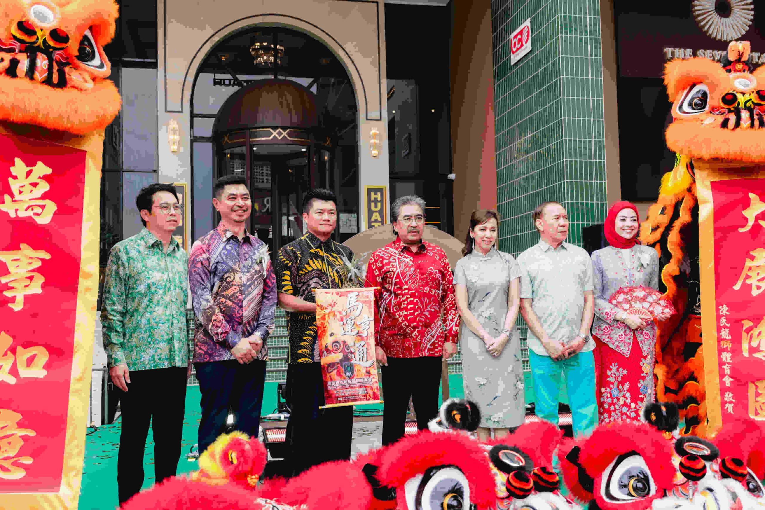 Tujuh wakil pengurusan dan tetamu kehormat bergambar bersama sepanduk perasmian diapit persembahan tarian singa di Chinatown 1974