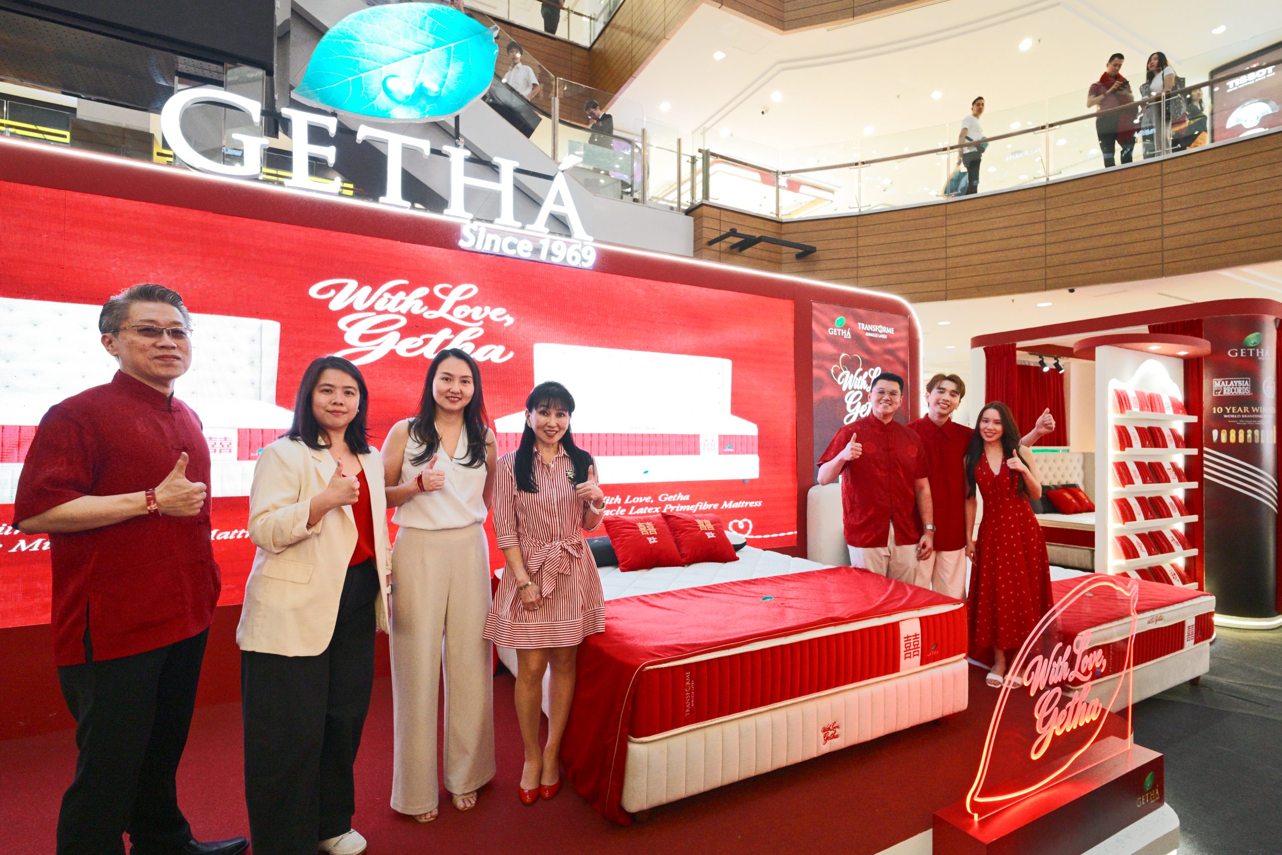 Six individuals posing in front of the red launch stage for the Getha wedding mattress collection