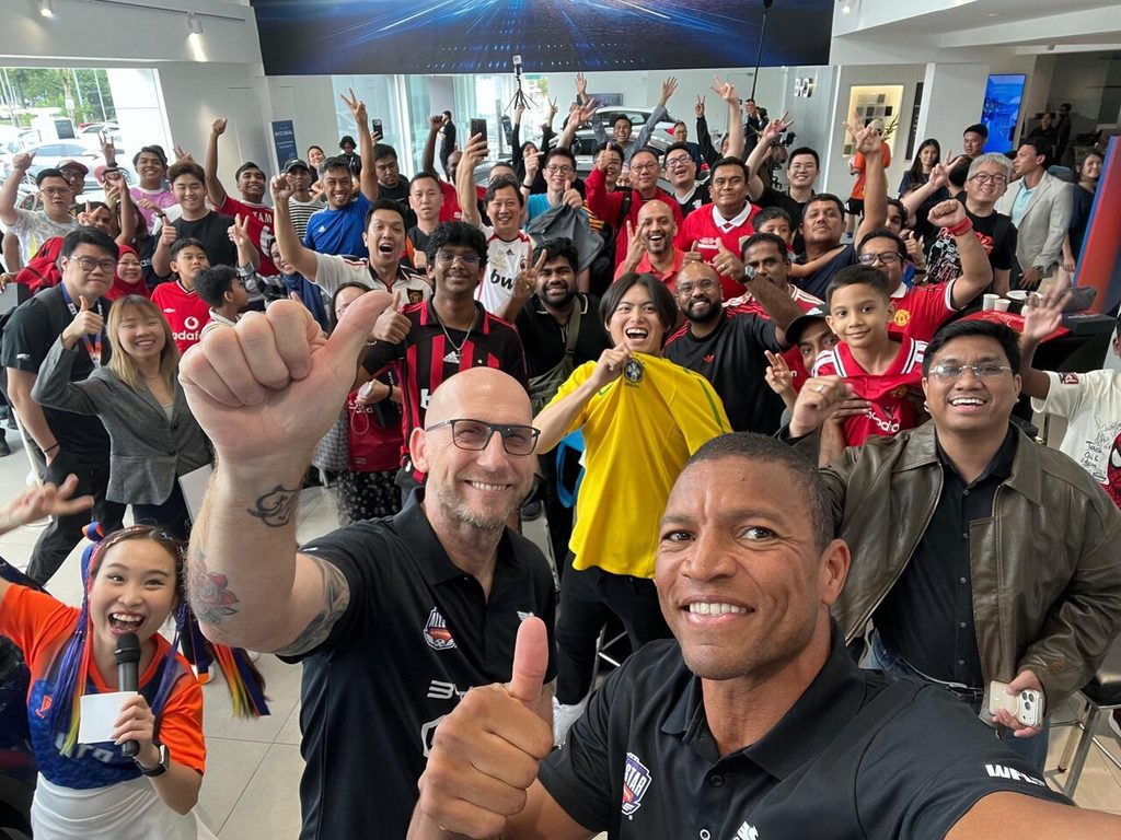 Bekas penjaga gol legenda Dida merakam swafoto sambil membuat isyarat bagus bersama peminat di bilik pameran BYD Sime Motors